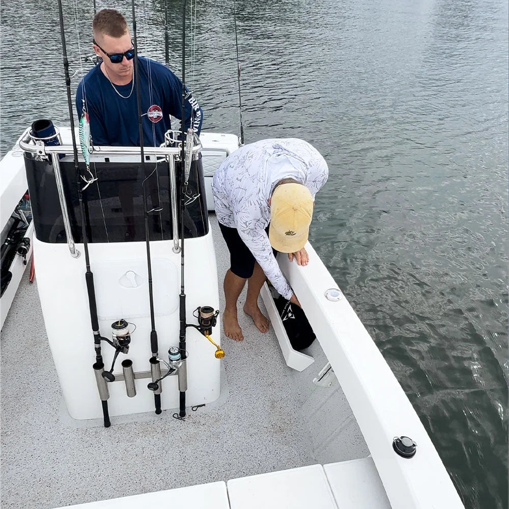A bagged anchor being handled beside a fishing boat storage compartment.