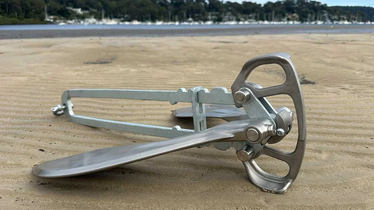 Active Anchor on a beach with a sailing boat in the background.