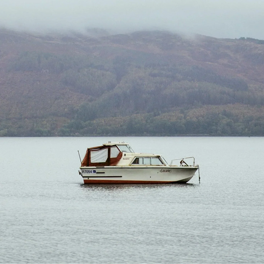 Image of a white boat in the middle of the sea surrounded by islands.