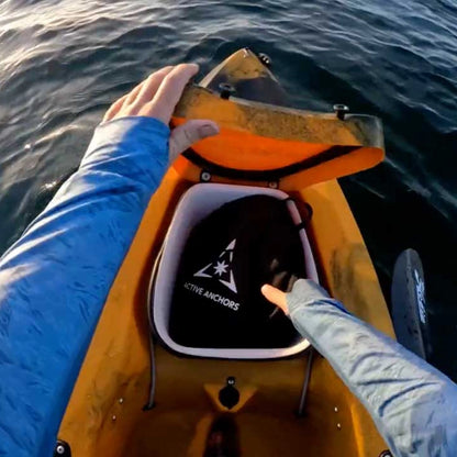 Active Anchors DF200 carry bag being stored in the rear storage compartment of a fishing kayak on the water.