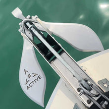 Active Anchors DF500 releasable marine anchor mounted on a boat's bow roller above the water, showing its curved stainless steel flukes.