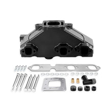 Exhaust manifold beside two gaskets and fitment hardware.