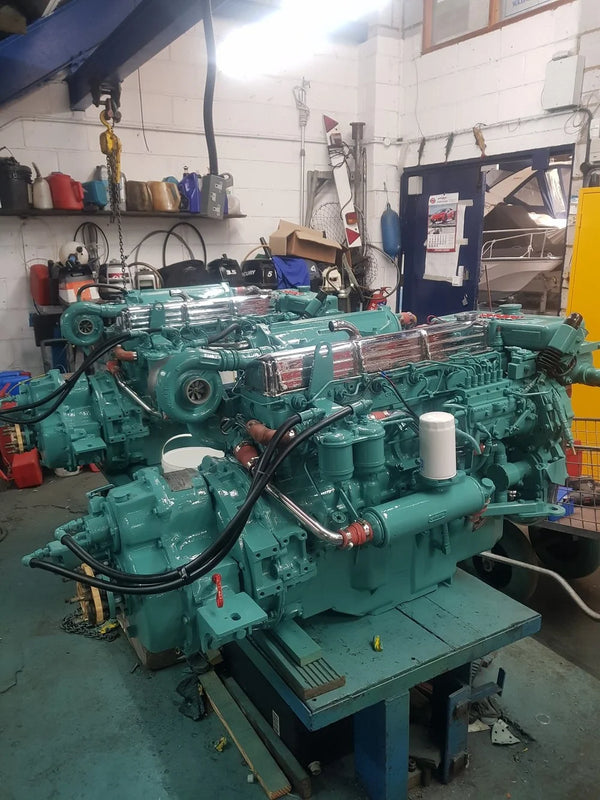 Image of a pair of green marine engines inside a workshop.