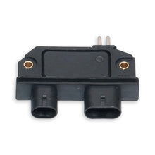 Black ignition module showing two plug connections and two metal pins at the top.