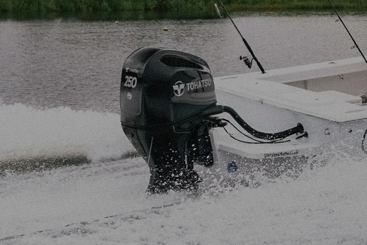 Image of a Tohatsu outboard engine being powered on the back of a boat going through the water.