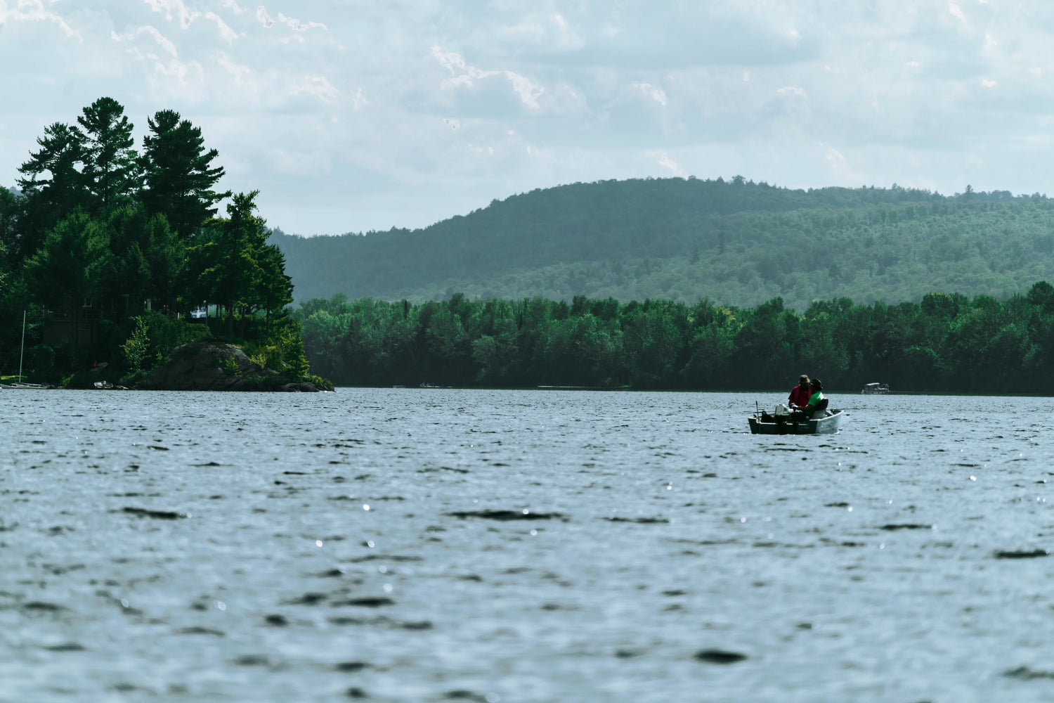 Image of a small boat on a lake surrounded by land.